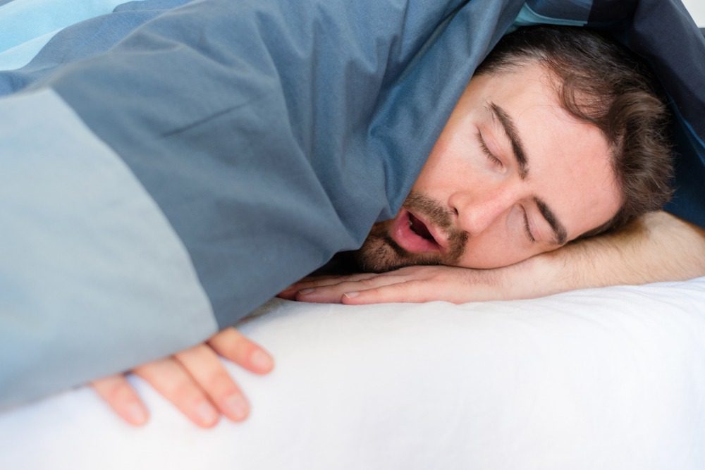 Man sleeping with open mouth showing snoring and mouth breathing issues related to airway and orthodontic concerns